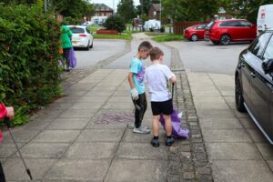 Two young people picking up litter in the community