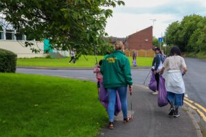A group of volunteers walking through Hunslet, picking up litter together