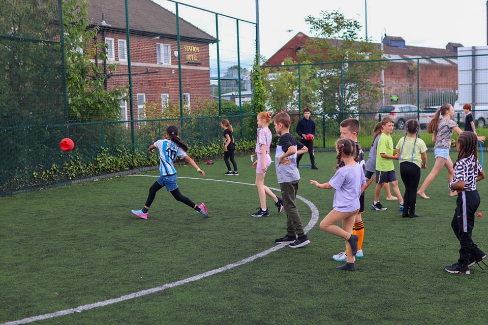 A group of young people playing football outside 