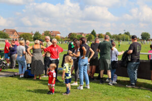 People crowded around a field at The Hunslet Club, watching a game of football