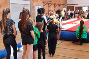 Young people inside, lining up waiting to showcase their gymnastic skills