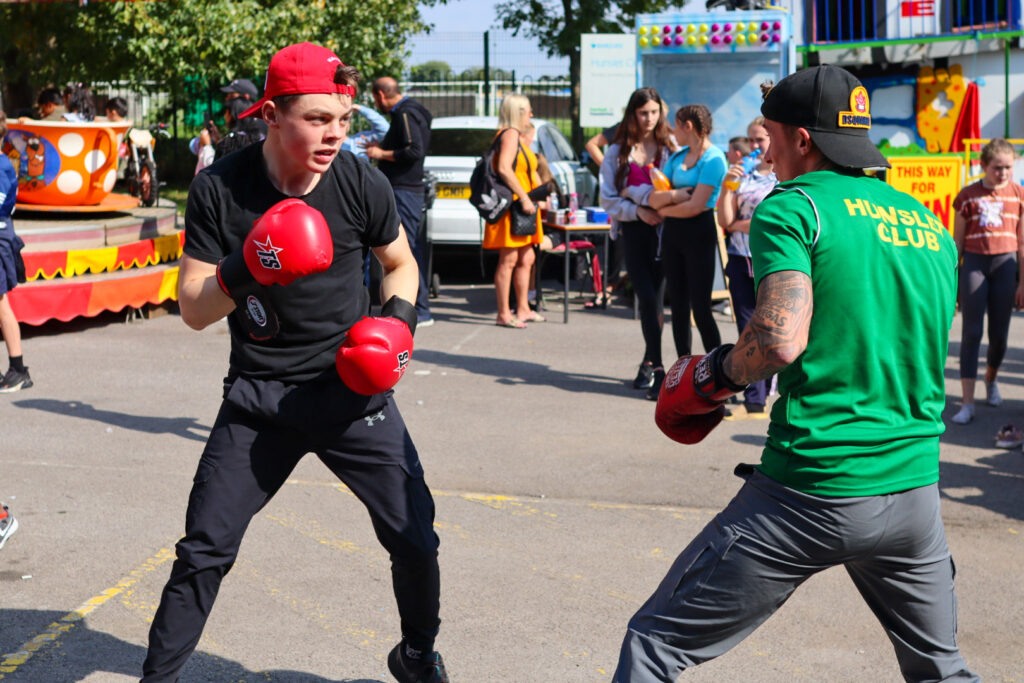Two people showing boxing techniques as people watch 