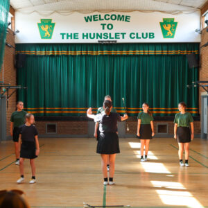 6 People in the main hall at The Hunslet Club, showcases their Majorettes skills.