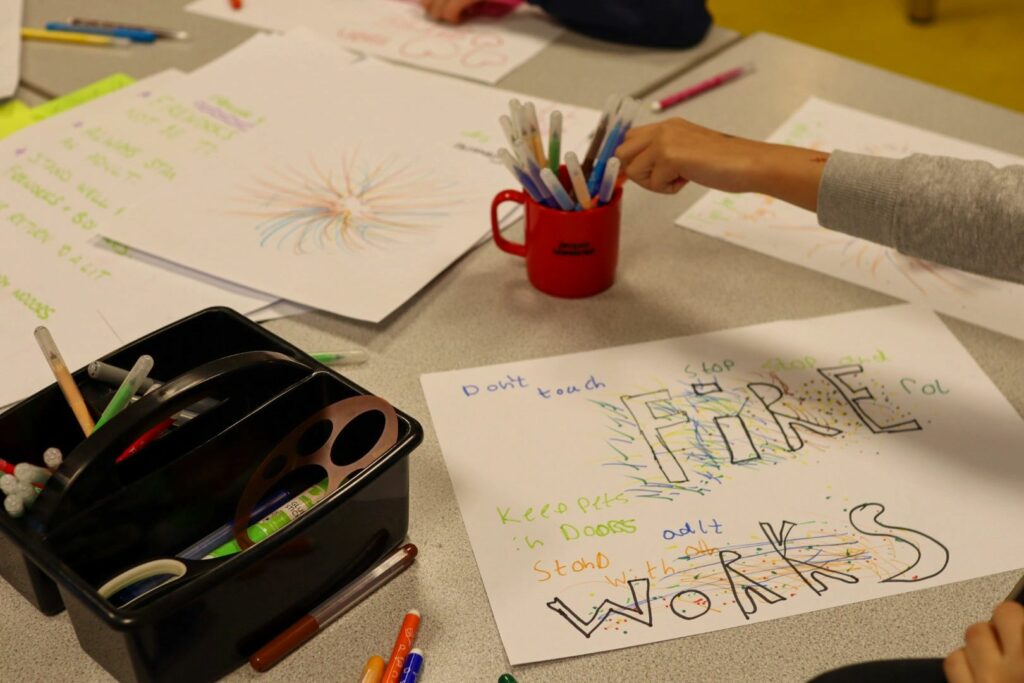 A table with different firework safety posters - all created by young people. 
